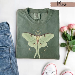 Moss green T-shirt with luna moth and crescent moon and celestial stars
