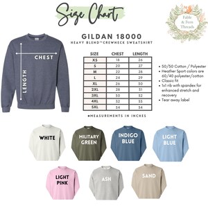 May include: Size chart for Gildan 18000 heavy blend crewneck sweatshirt. The chart shows chest and length measurements in inches for sizes XS to 5XL. The sweatshirt is available in 10 colors: white, military green, indigo blue, light blue, light pink, ash, sand, black, navy, and heather grey.