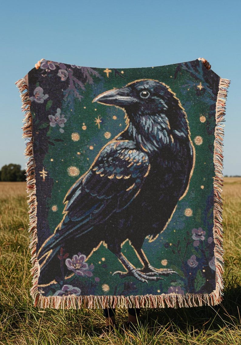 Raven woven blanket with a side profile of a raven with a yellow highlight around it a teal background and flowers in the corners witchy tapestry