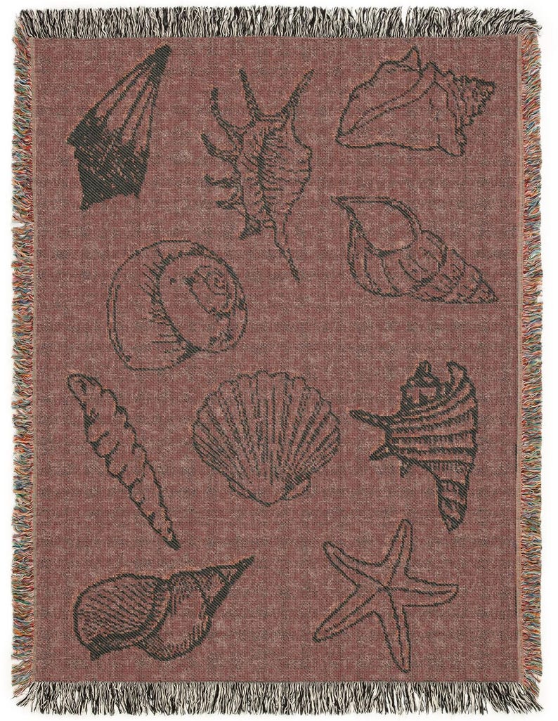 May include: A red woven throw blanket with a pattern of various seashells in black and white. The blanket has a fringe border.