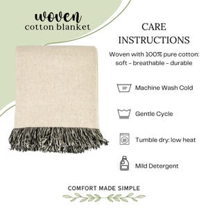 May include: A woven cotton blanket in a light beige color with dark fringe at the bottom. The text reads: woven cotton blanket, CARE INSTRUCTIONS, Woven with 100% pure cotton: soft - breathable - durable, Machine Wash Cold, Gentle Cycle, Tumble dry: low heat, Mild Detergent, COMFORT MADE SIMPLE.