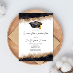 May include: A graduation announcement with a black and gold watercolor design. The invitation features a graduation cap illustration and the text "Graduation Celebration" honoring Dr. Benjamin Jackson. The announcement is on a wooden plate with an envelope and cotton accents.