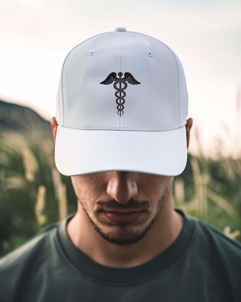 May include: A white baseball cap with a black caduceus emblem. The cap has a curved peak and a structured crown. The design is centrally placed on the front, providing a clean and professional appearance. A versatile accessory.