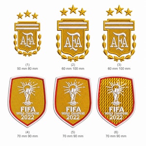 Puede incluir: Seis parches bordados con diseños en dorado y blanco. Fila superior: tres escudos AFA con tres estrellas, de 50 mm por 80 mm o 60 mm por 100 mm. Fila inferior: tres parches en forma de escudo FIFA World Champions 2022, de 70 mm por 90 mm.