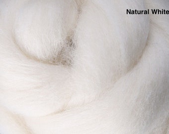 May include: Close-up of natural white wool roving. The fluffy, soft fiber is tightly packed and ready for spinning or felting. The text "Natural White" is visible in the upper right corner.