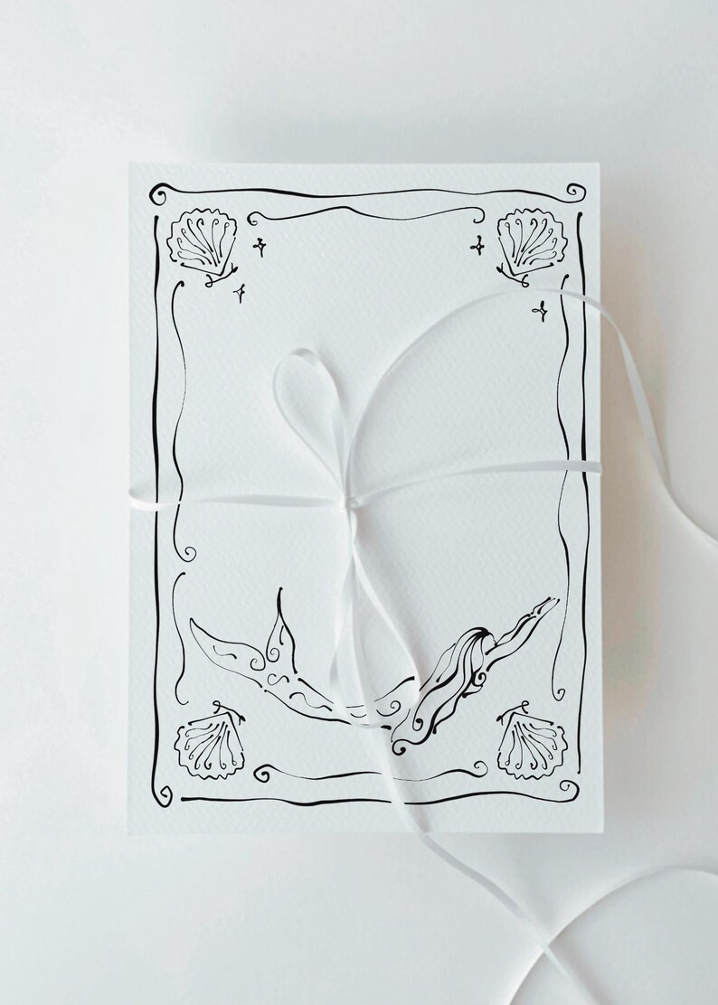 Pu&ograve; includere: Biglietto bianco con un disegno a tratto nero di una sirena e conchiglie. Il biglietto &egrave; legato con un nastro bianco. L'illustrazione della sirena &egrave; centrata.