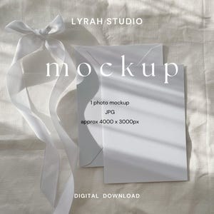 Maqueta de tarjeta de papelería plana con sobre blanco y cinta blanca / Foto minimalista con estilo de invitación