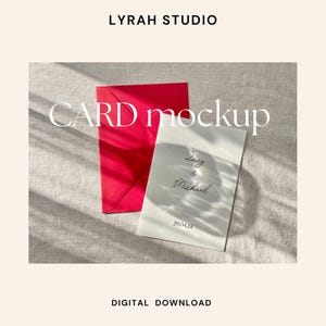 Puede incluir: Una maqueta de tarjeta blanca con el texto "Lucy & Michael 28.04.23" sobre un fondo de lino con un sobre rojo.