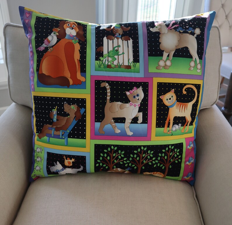 Pu&ograve; includere: Un cuscino bianco e nero con un design a patchwork colorato che presenta vari animali, tra cui cani, gatti e uccelli. Il cuscino ha uno sfondo nero con pois bianchi ed &egrave; decorato con quadrati colorati che presentano diversi animali e scene.