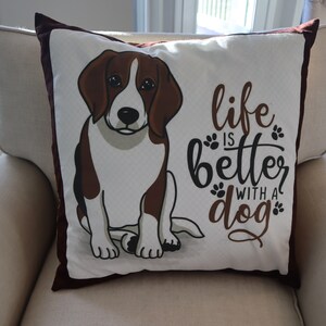 Pu&ograve; includere: Un cuscino bianco con un'illustrazione di un beagle marrone e bianco e il testo "life is better with a dog".