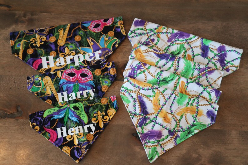 May include: Three colorful dog bandanas with Mardi Gras themed fabric. The bandanas are black with gold and green accents and feature a purple, green, and gold beaded pattern. The bandanas are personalized with the names "Harper", "Harry", and "Henry".