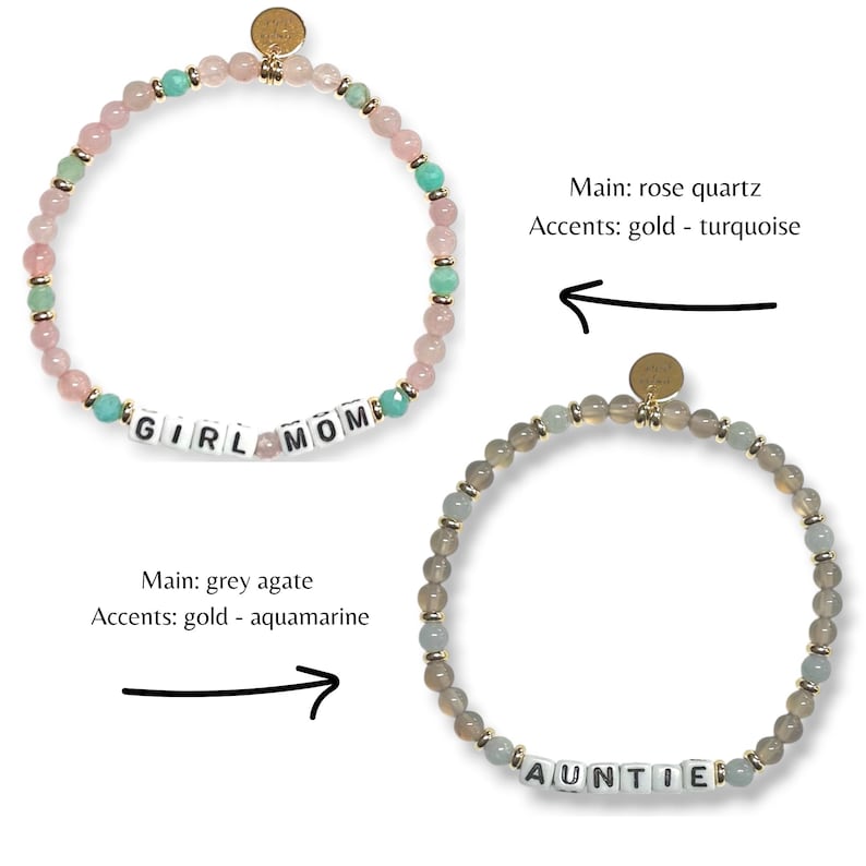 May include: Two beaded bracelets. One features rose quartz beads, turquoise accents, and the word "GIRL MOM". The other bracelet has grey agate beads, aquamarine accents, and the word "AUNTIE". Both bracelets have gold-colored accents.