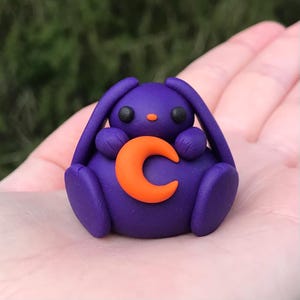 Cute purple bunny holding a moon polymer clay figurine, desk buddy