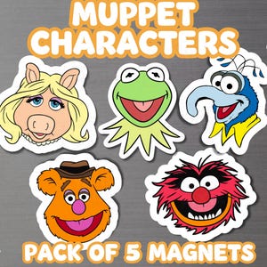 May include: A set of five Muppet character magnets featuring Miss Piggy, Kermit the Frog, Gonzo, Fozzie Bear, and Animal. The text MUPPET CHARACTERS and PACK OF 5 MAGNETS is displayed in orange. A small magnet icon is visible in the top right corner.