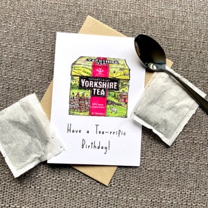May include: A birthday card with a hand-drawn illustration of a box of Yorkshire Tea. The card has the text "Have a Tea-rrific Birthday!" on it.