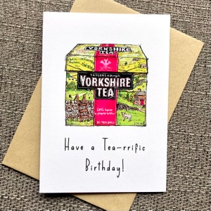 May include: A birthday card featuring a cartoon illustration of a box of Yorkshire Tea with the text "Let's have a proper brew" and "80 tea bags". The card has the text "Have a Tea-rrific Birthday!" written below the illustration.