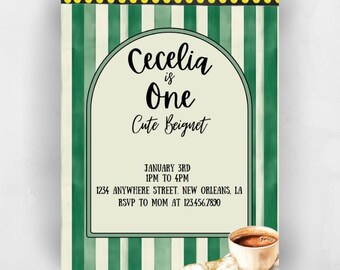 Puede incluir: Una invitación a rayas verdes y blancas con un borde de lunares amarillos. La invitación dice "Cecelia tiene un año, un beignet lindo" e incluye detalles para una fiesta el 3 de enero de 1 PM a 4 PM en 1234 Anywhere Street, Nueva Orleans, LA. RSVP a mamá al 123.456.7890. La invitación presenta una ilustración de acuarela de un beignet y una taza de café.