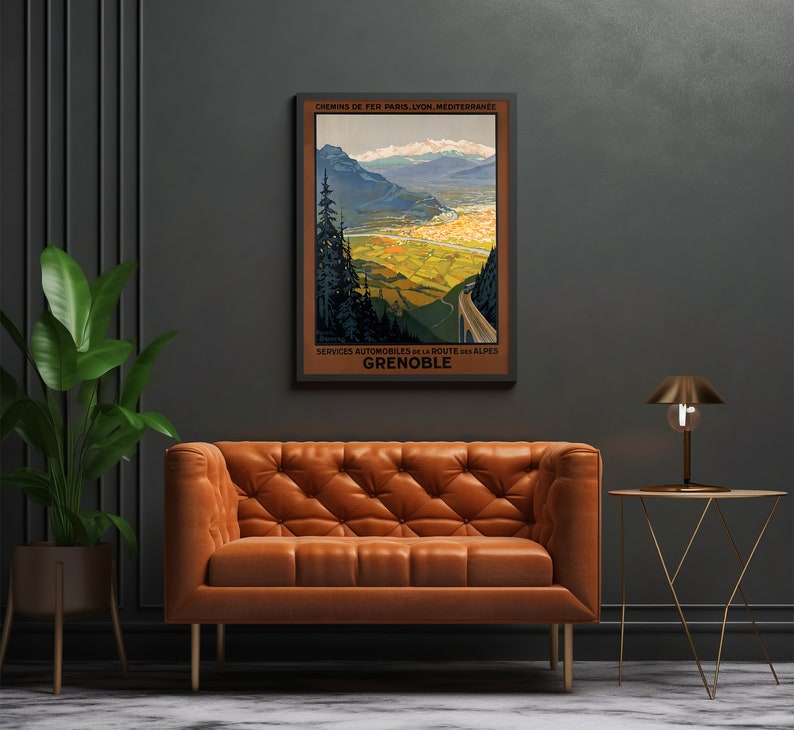 May include: Vintage travel poster depicting a scenic mountain landscape with a winding road leading to the town of Grenoble, France. The poster is in shades of green, brown, and blue, with the text "Chemins de Fer Paris, Lyon, Mediterranee" and "Services Automobiles de la Route des Alpes" at the top and bottom, respectively.