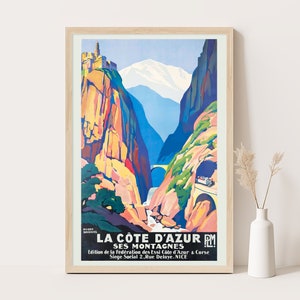 May include: A vintage travel poster advertising the French Riviera, featuring a colourful illustration of a mountain range with a winding road and a tunnel. The text reads "La Côte d'Azur PM Ses Montagnes" and includes the organisation's name and address.