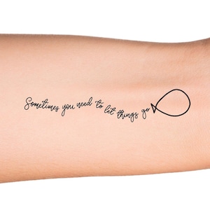 May include: A temporary tattoo with the text "Sometimes you need to let things go" and a simple balloon illustration.