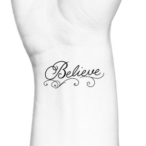 May include: A temporary tattoo with the word "Believe" written in a cursive font with decorative swirls.