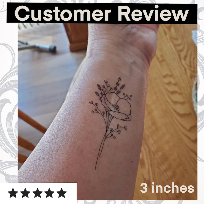 Puede incluir: Un tatuaje temporal en blanco y negro de una flor con una sola flor grande y flores m&aacute;s peque&ntilde;as que la rodean. El tatuaje mide 7,6 cm.