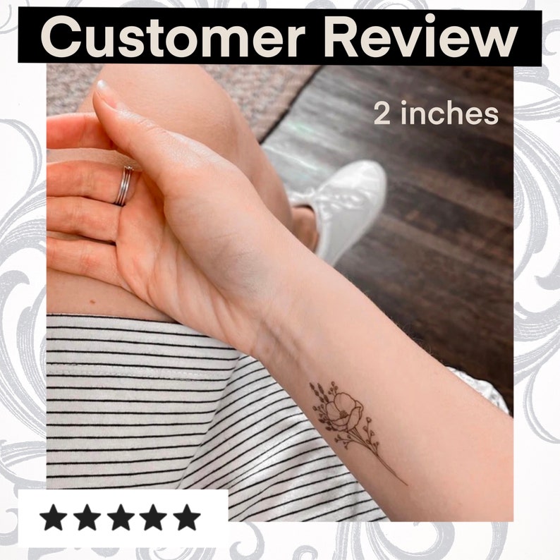 Puede incluir: Cinco estrellas para un tatuaje temporal de un peque&ntilde;o dibujo en l&iacute;nea negra de una flor con tallos y hojas. El tatuaje est&aacute; en la mu&ntilde;eca de una persona y mide 5 cm.