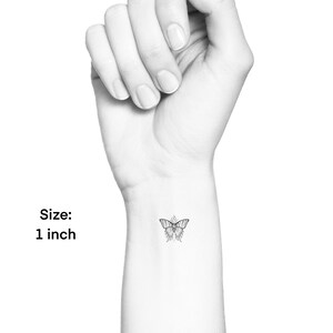 May include: A small, black and white line drawing of a butterfly on a person's wrist. Size: 1 inch.