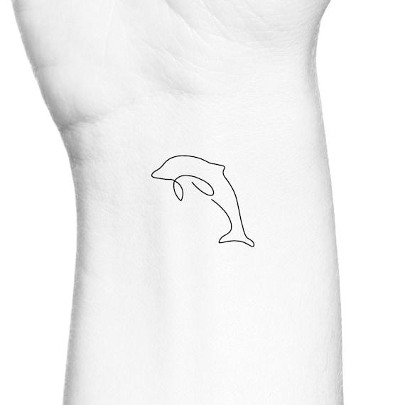 Minimalistic style dolphin tattoo located on the foot.