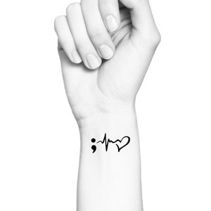May include: A black and white temporary tattoo featuring a semicolon, a heartbeat, and a heart.