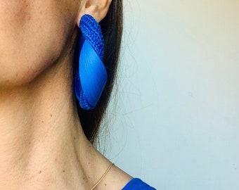 Peut inclure: Une paire de grandes boucles d'oreilles créoles en crochet bleu. Les boucles d'oreilles sont torsadées et ont un design unique et moderne.