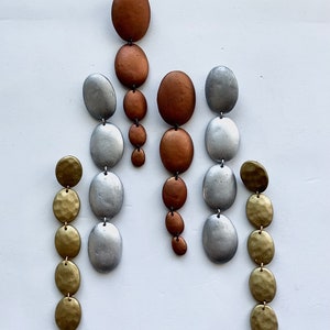 May include: Three pairs of dangle earrings with multiple round beads in silver, gold, and copper tones.
