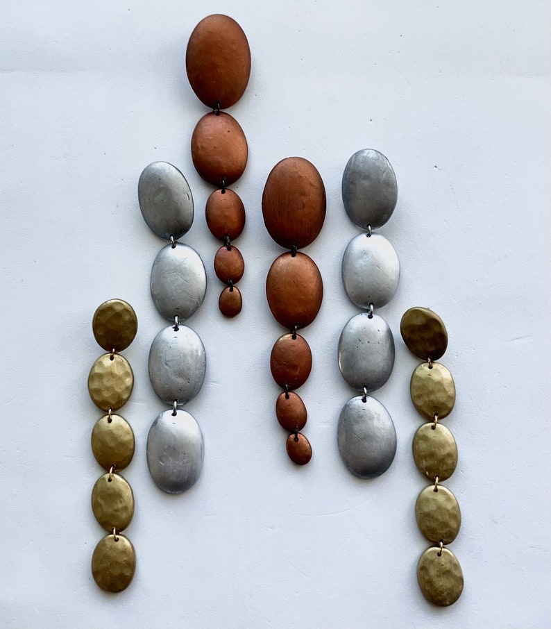 May include: Three pairs of dangle earrings with multiple round beads in silver, gold, and copper tones.