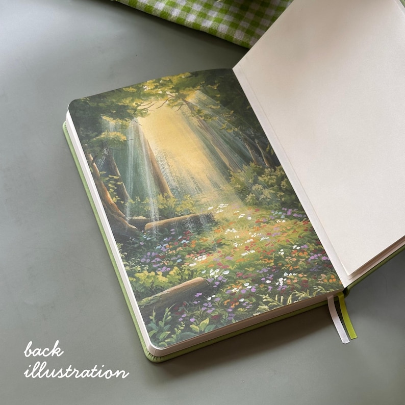 May include: Open green journal with a forest illustration on the back cover. The illustration depicts a sunlit forest scene with trees, wildflowers, and a stream of light. The text "back illustration" is visible.