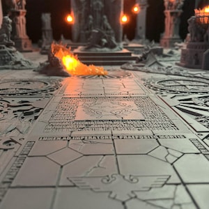 Puede incluir: Diorama en miniatura gris detallado de un interior de templo, con intrincadas tallas, pilares y un camino central. La escena incluye un elemento de fuego y una iluminación cálida, creando una atmósfera dramática. El suelo tiene texto y símbolos grabados.