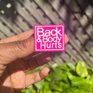 May include: A pink square pin with white text that reads "Back & Body Hurts".