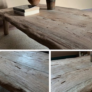 K&ouml;nnte beinhalten: Ein rustikaler, hellbrauner Couchtisch aus Holz mit einer nat&uuml;rlichen, unregelm&auml;&szlig;igen Kante. Der Tisch hat sichtbare Holzmaserung und Knoten und wird von vier stabilen Beinen getragen. Zwei B&uuml;cher und eine kleine Vase stehen auf dem Tisch.