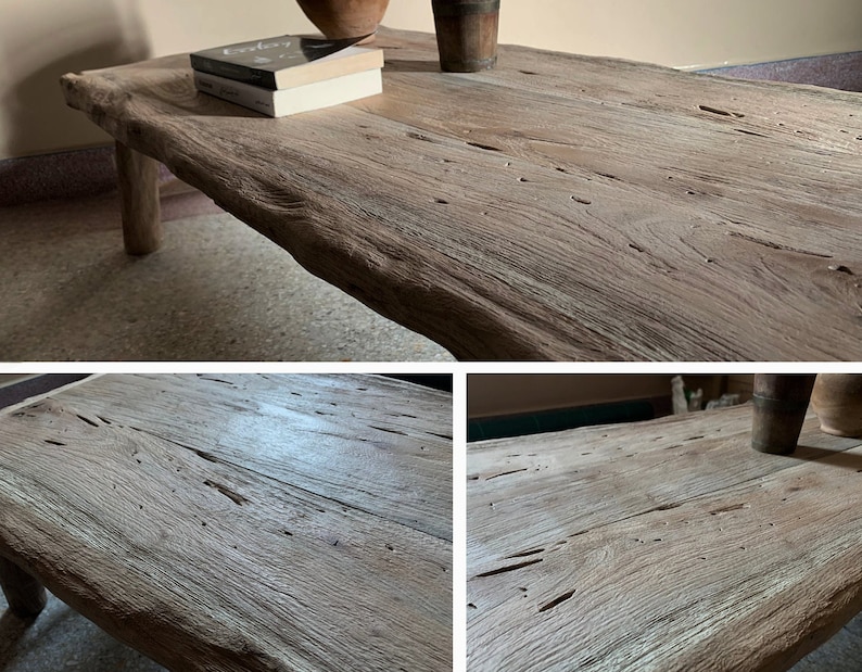 K&ouml;nnte beinhalten: Ein rustikaler, hellbrauner Couchtisch aus Holz mit einer nat&uuml;rlichen, unregelm&auml;&szlig;igen Kante. Der Tisch hat sichtbare Holzmaserung und Knoten und wird von vier stabilen Beinen getragen. Zwei B&uuml;cher und eine kleine Vase stehen auf dem Tisch.