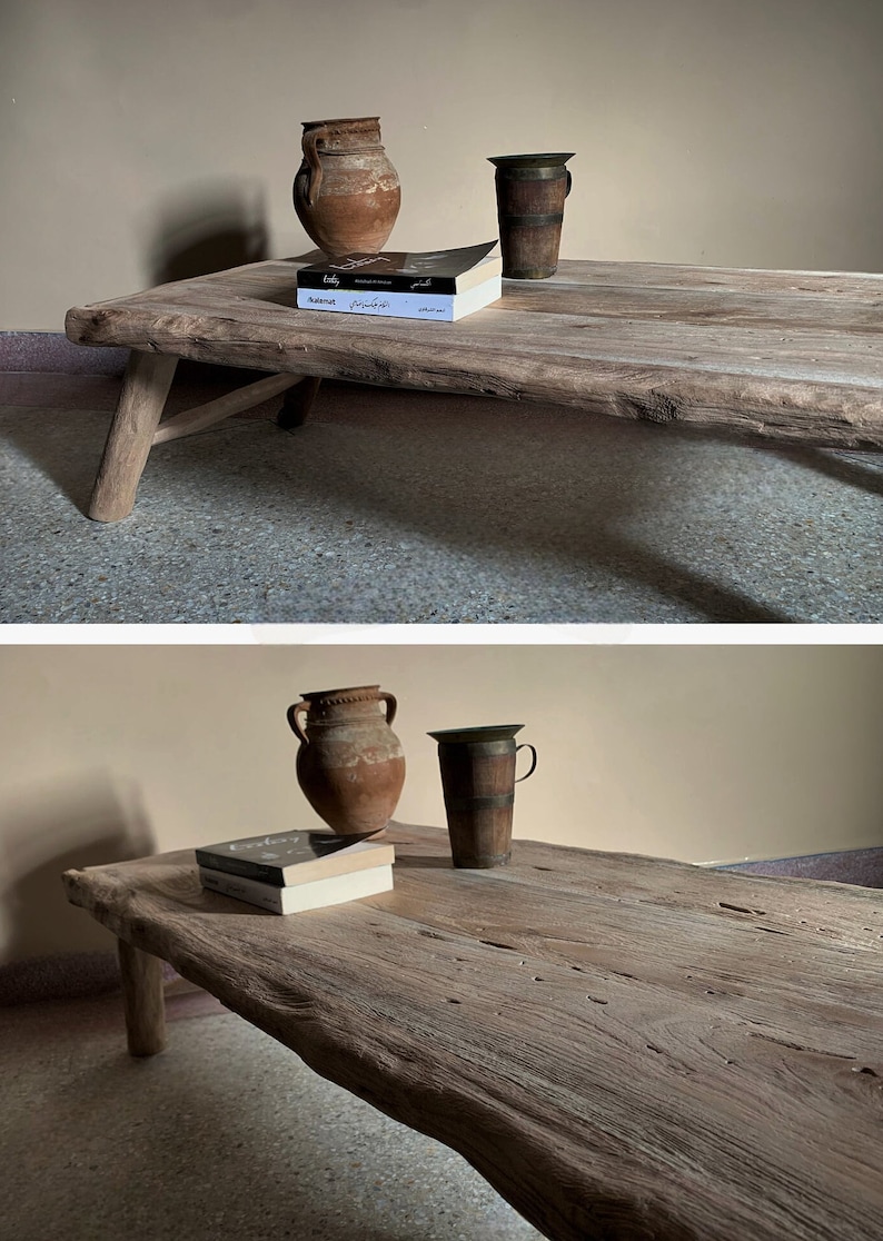 K&ouml;nnte beinhalten: Ein rustikaler Couchtisch aus Holz mit nat&uuml;rlicher Kante. Er zeigt zwei Terrakotta-Vasen, einen Holzbecher und zwei B&uuml;cher. Der Tisch hat schr&auml;ge Beine und das Holz hat eine hellbraune Farbe. Der Tisch ist etwa 150 cm lang.