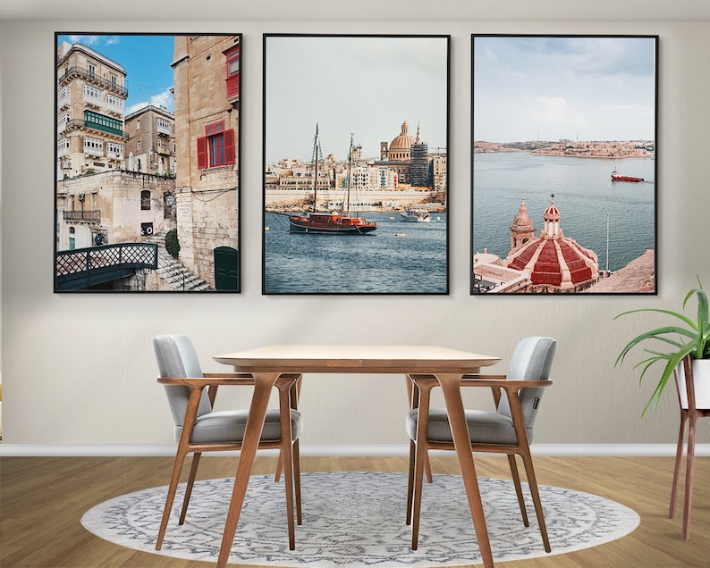 May include: Three framed prints of scenes from Valletta, Malta. The first print shows a narrow street with colorful buildings and a bridge. The second print shows a harbor with a sailboat and a church in the background. The third print shows a church with a red dome and a view of the harbor.