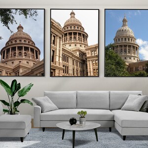 Puede incluir: Tres impresiones enmarcadas del edificio del Capitolio del Estado de Texas en Austin, Texas. Las impresiones están en marcos negros y están colgadas en una pared blanca sobre un sofá seccional gris.