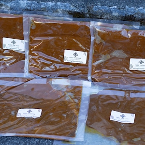 May include: Five clear plastic bags filled with a brown, honey-like substance. Each bag has a white label with the text "Feed the Hive" and "Spring/Summer Patty".