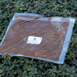 May include: A clear plastic bag filled with a brown liquid, labeled "Feed the Hive Spring/Summer Pollen".
