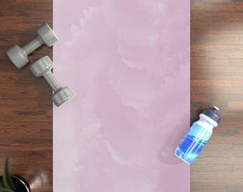 May include: A purple yoga mat with a watercolor cloud design. Two gray dumbbells and a blue water bottle are on a wooden floor next to the mat.