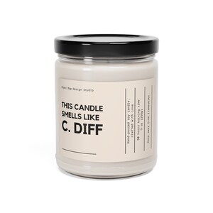 May include: A glass jar candle with a black lid. The label reads "This candle smells like C. Diff" and includes information about the candle, such as the burn time and size.