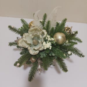 Pièce maîtresse de composition florale artificielle de table de Noël dans un pot noir. Fleur dorée, boules. Baies blanches, Branches d&#39;épicéa, Guirlande de perles