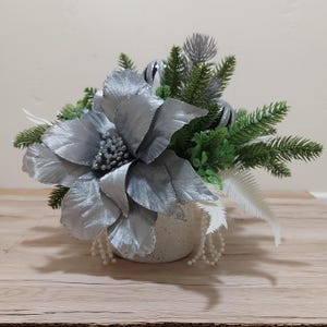 Kerstkunstbloemstuk, zilveren ballen, bloemen, bladeren, sparren, witte bessen, kralenslingers