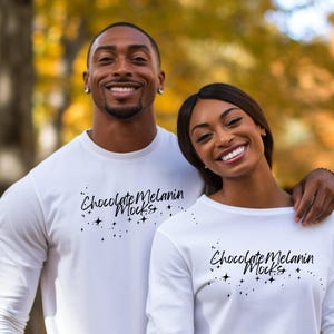 May include: A couple wearing white long-sleeved shirts with the text "Chocolate Melanin Mocks" and a design of stars.