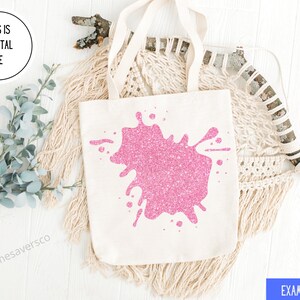 Pu&ograve; includere: Una borsa tote color crema con un grande design a spruzzo di glitter rosa. La borsa ha manici color crema e il testo "THIS IS A DIGITAL FILE" in un cerchio. Il testo "EXAMPLE USE" &egrave; in un rettangolo blu.