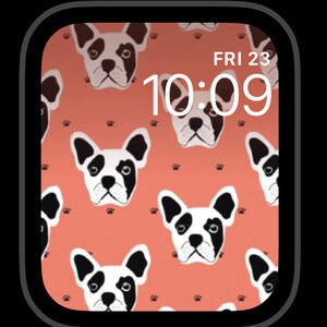 Op de afbeelding: Een digitaal horloge-scherm met een roze achtergrond en een patroon van zwarte en witte Franse bulldoggezichten. De tijd is 10:09 en de dag is vrijdag de 23e.
